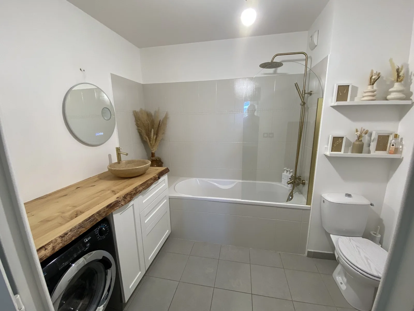 Salle de bain rénovée avec bois et robinetterie dorée